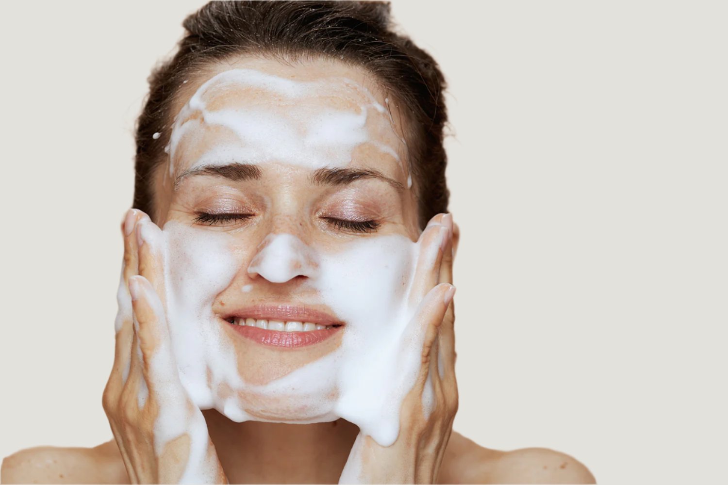 A lady washing face with foaming soap